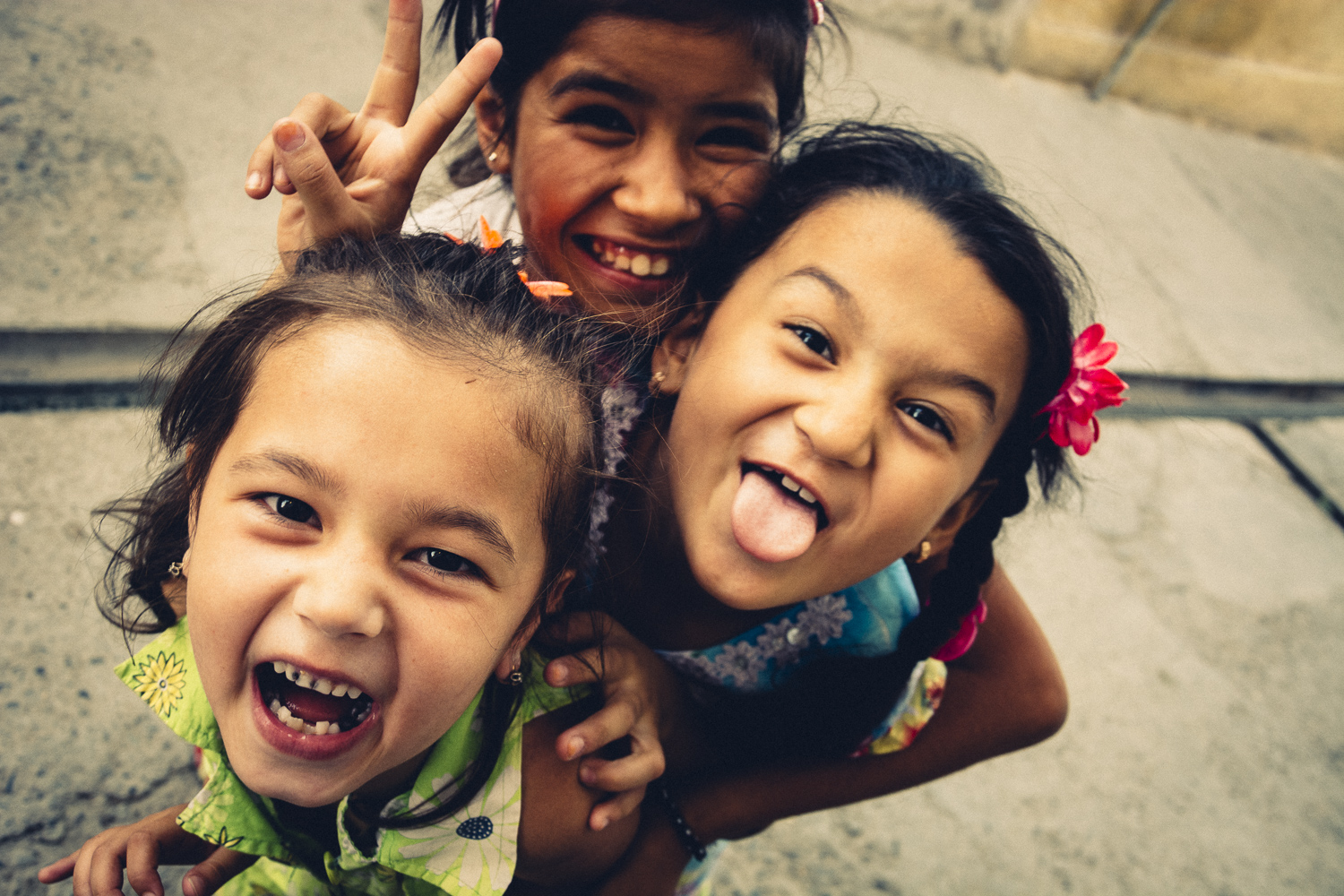 Close up Image of three young girls, laughing into the camera in the jewish quarter in Samarkand, Uzbekistan.